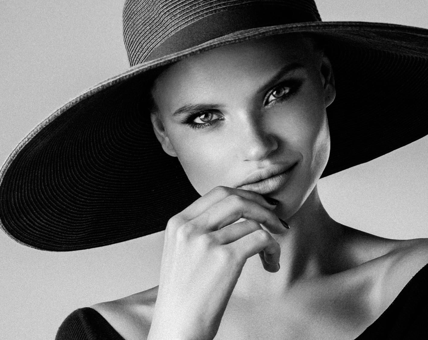 Black and white photo of a woman wearing a big hat