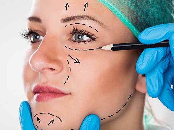 cosmetic surgeon drawing on a female patients face