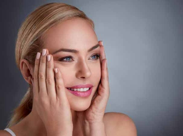 Beautiful blonde woman cupping her face.
