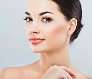 Pretty young charming smiling woman close-up on a gray background